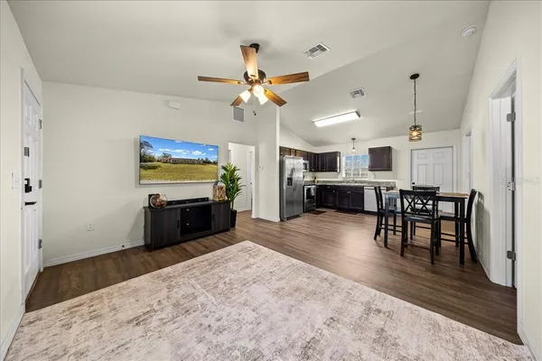 a kitchen with a table chairs stainless steel appliances and cabinets