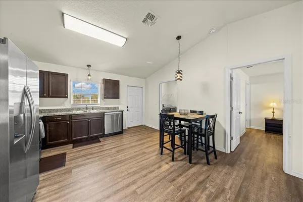 a kitchen with stainless steel appliances granite countertop a stove a sink and a microwave