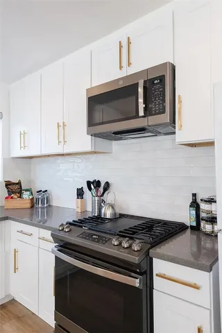 a kitchen with stainless steel appliances granite countertop white cabinets a stove and dishwasher