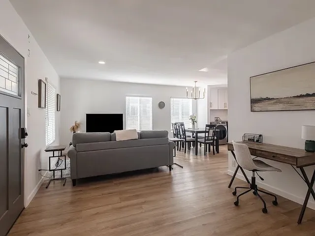 a living room with furniture and a wooden floor