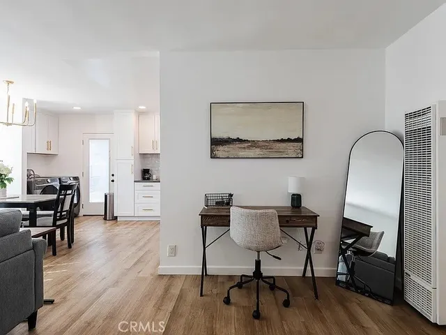 a view of a workspace with furniture and wooden floor