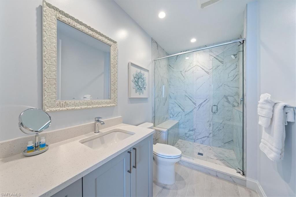 1115 Central Avenue, Unit 445 Naples, FL 34102 - Photo 11 of 20 a bathroom with a sink shower and a toilet