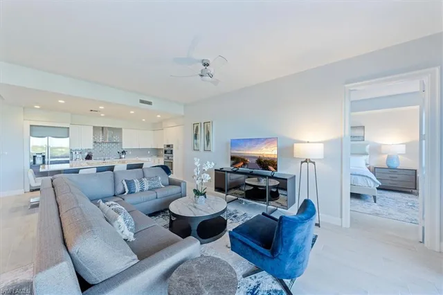 a living room with furniture a flat screen tv and kitchen view