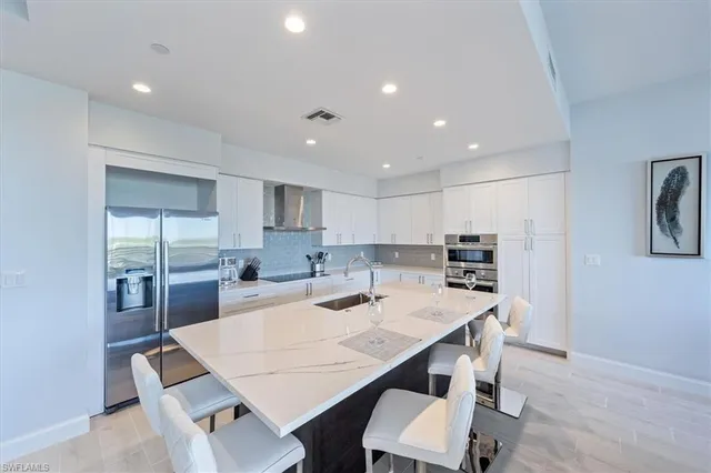 a kitchen with a dining table chairs and refrigerator