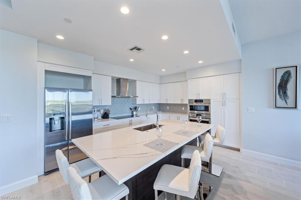 1115 Central Avenue, Unit 445 Naples, FL 34102 - Photo 4 of 20 a kitchen with a dining table chairs and refrigerator