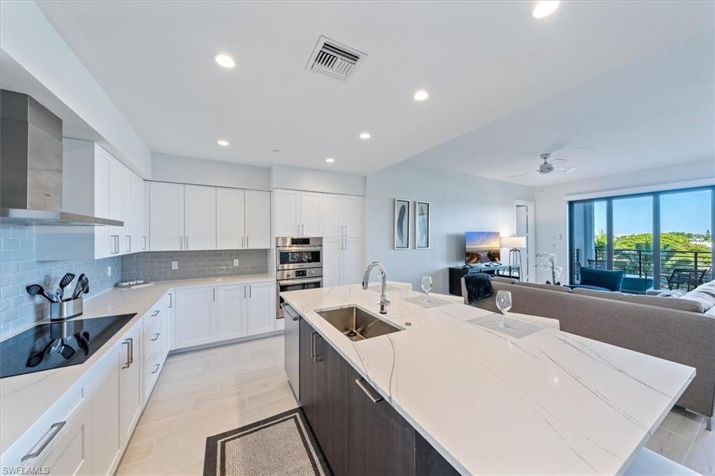 1115 Central Avenue, Unit 445 Naples, FL 34102 - Photo 5 of 20 a kitchen with a sink a counter top space stainless steel appliances and cabinets