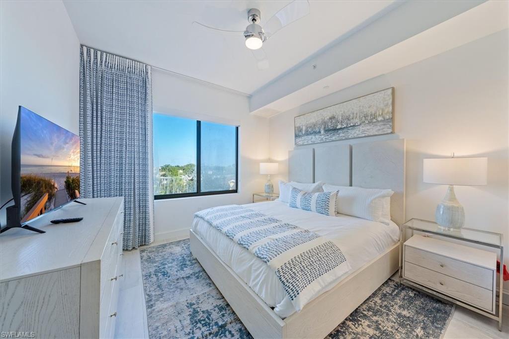 1115 Central Avenue, Unit 445 Naples, FL 34102 - Photo 7 of 20 a bedroom with a bed a dresser and potted plants