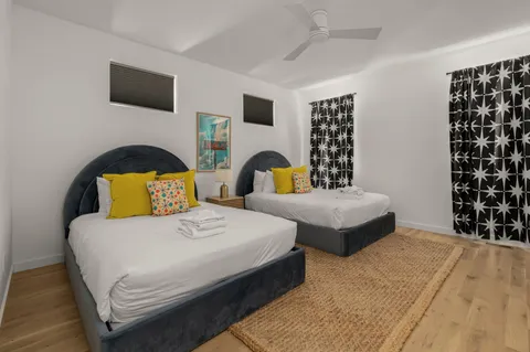 a bedroom with a bed lamps and wall painting