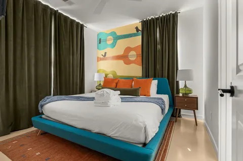 a bedroom with a bed and a flat tv screen on dresser