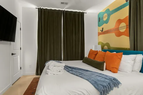 a bedroom with a bed and a painting on the wall