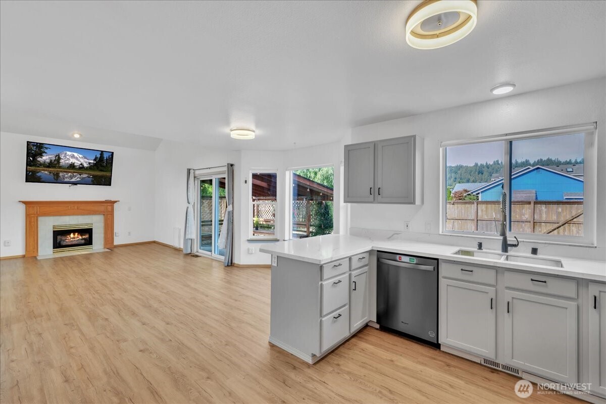 322 Orting Avenue Northwest Orting, WA 98360 - Photo 11 of 36 a kitchen with a sink cabinets and wooden floor