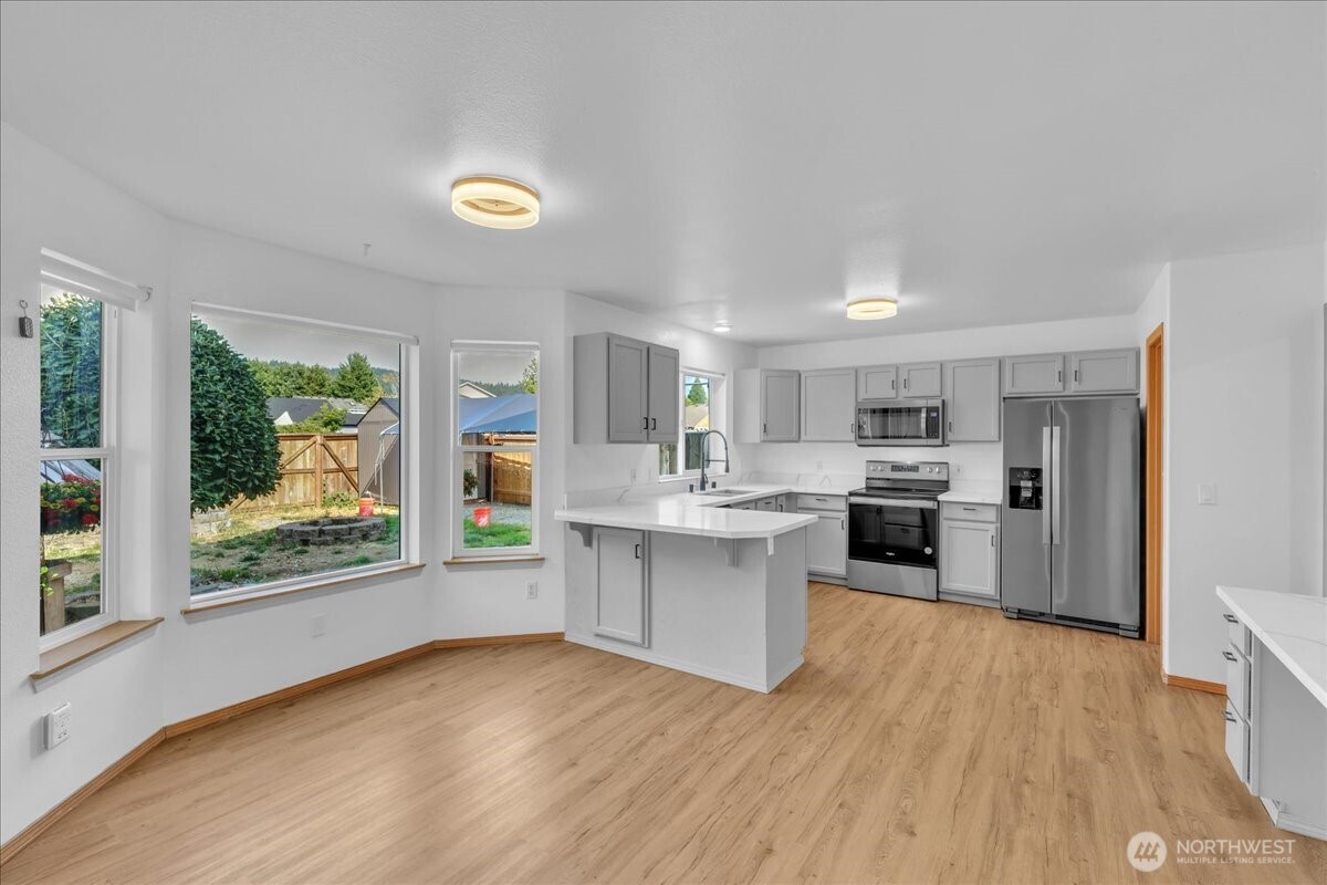 322 Orting Avenue Northwest Orting, WA 98360 - Photo 12 of 36 a kitchen with stainless steel appliances granite countertop a stove and a sink