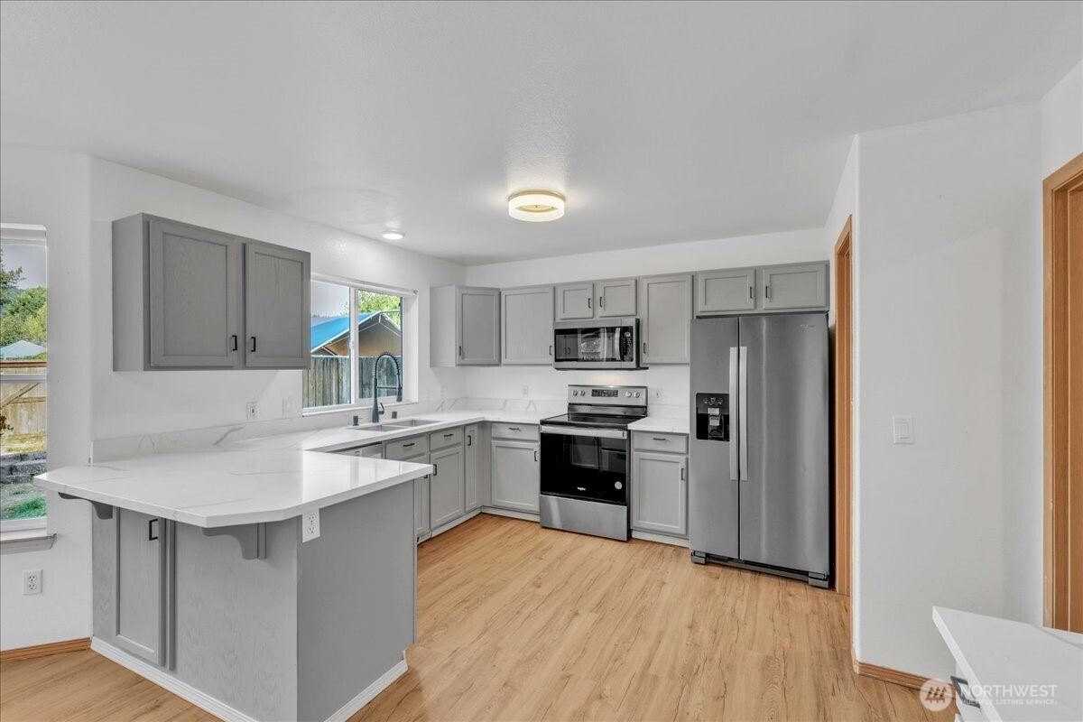 322 Orting Avenue Northwest Orting, WA 98360 - Photo 13 of 36 a kitchen with stainless steel appliances a sink stove and refrigerator