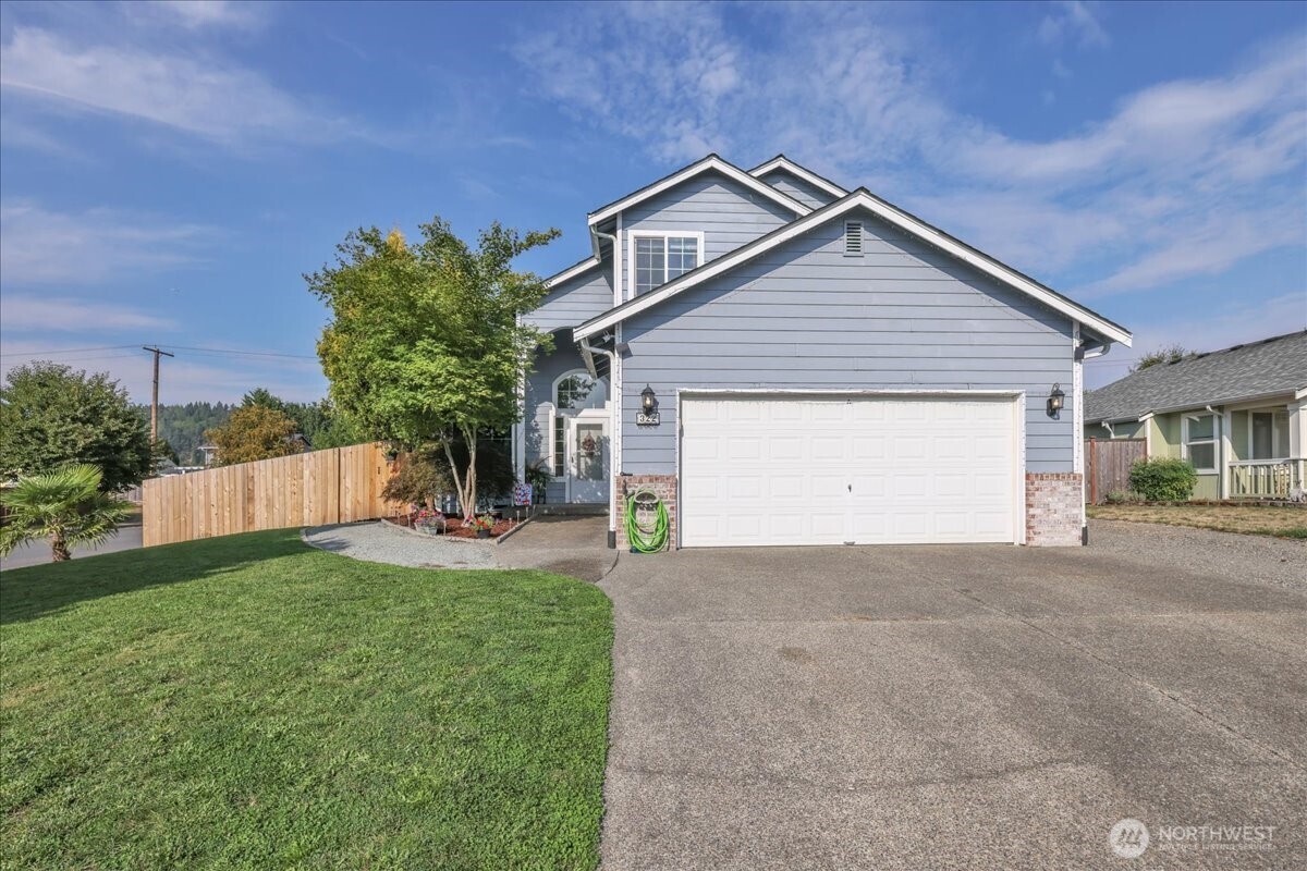 322 Orting Avenue Northwest Orting, WA 98360 - Photo 2 of 36 a view of a house with a yard and garage