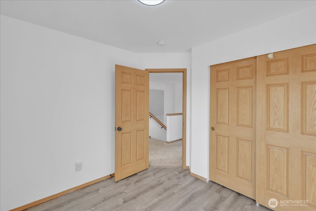 322 Orting Avenue Northwest Orting, WA 98360 - Photo 24 of 36 an empty room with wooden floor and closet area