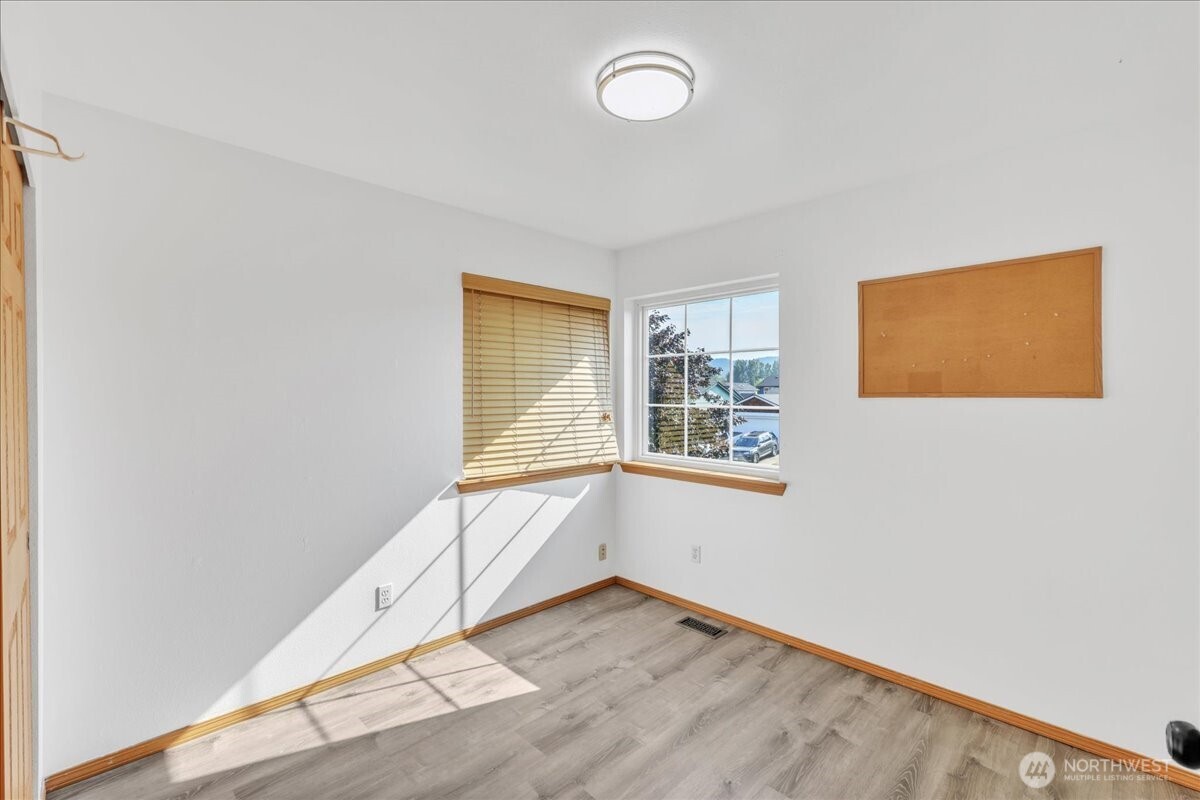 322 Orting Avenue Northwest Orting, WA 98360 - Photo 26 of 36 an empty room with wooden floor and windows