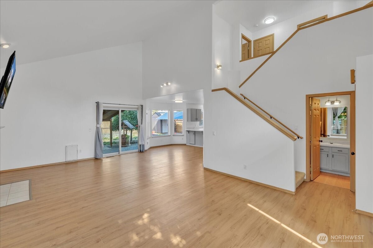 322 Orting Avenue Northwest Orting, WA 98360 - Photo 6 of 36 a view of a hallway with wooden floor and a living room