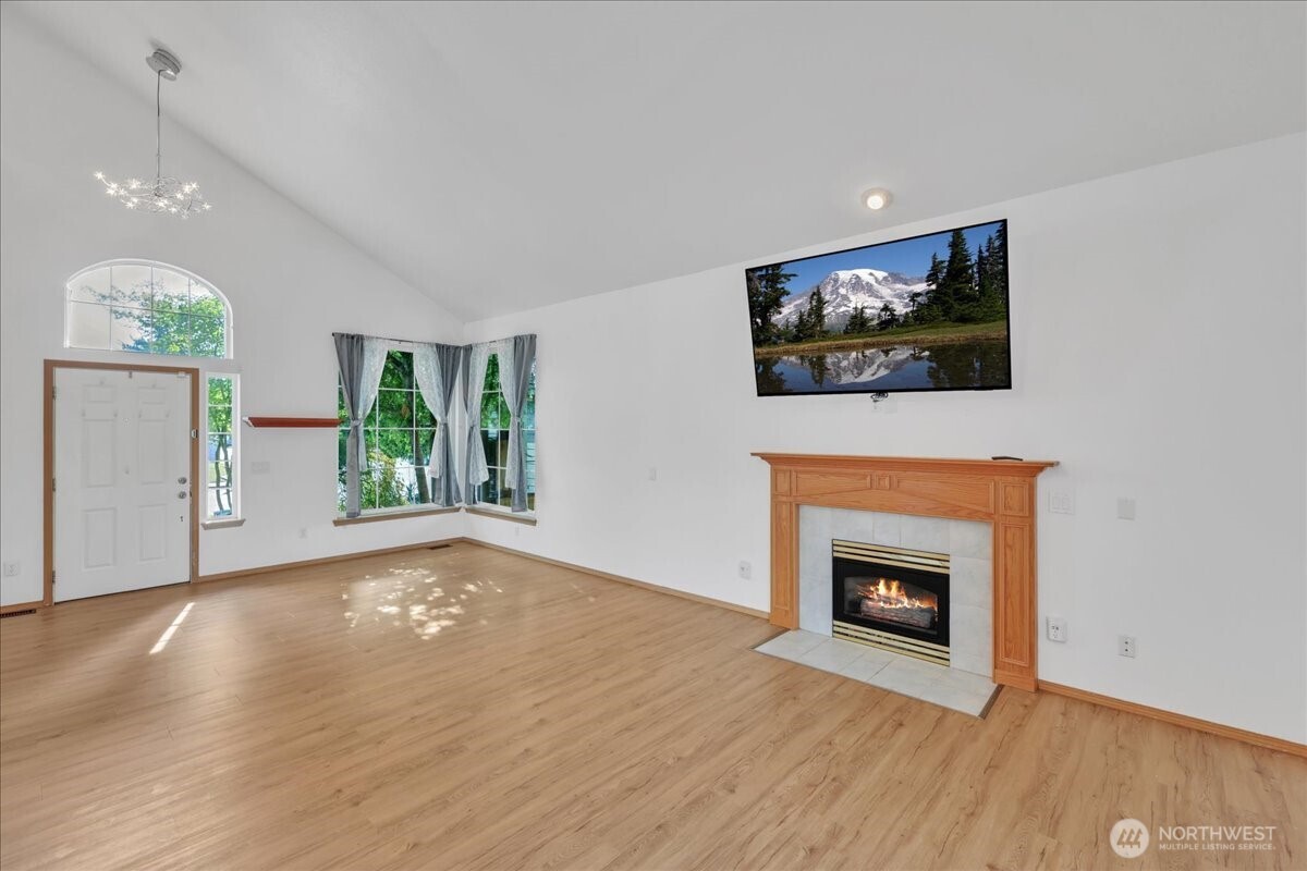 322 Orting Avenue Northwest Orting, WA 98360 - Photo 7 of 36 a view of empty room with wooden floor and fireplace