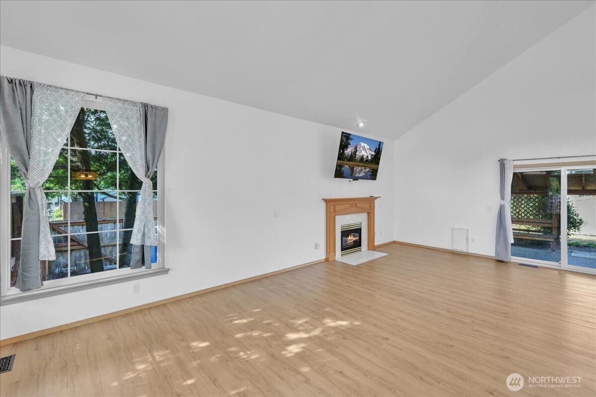 322 Orting Avenue Northwest Orting, WA 98360 - Photo 9 of 36 an empty room with windows and fireplace