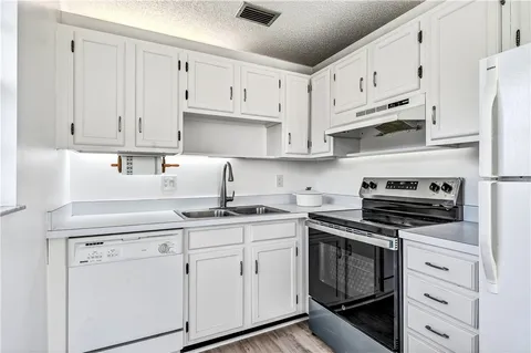 a kitchen with cabinets stainless steel appliances and wooden floor