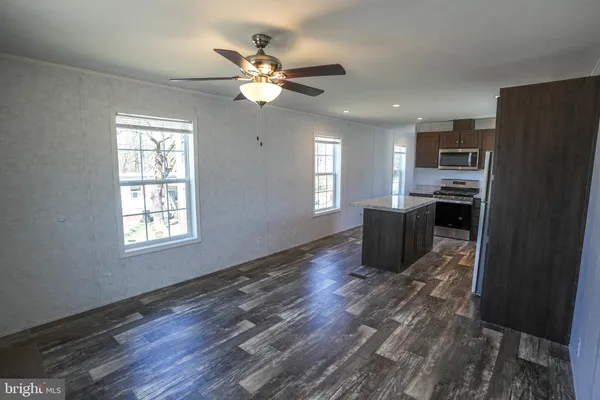 a living room with stainless steel appliances kitchen island granite countertop furniture and a window