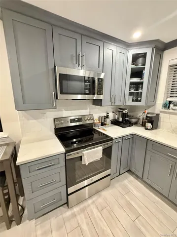 a kitchen with stainless steel appliances a stove sink microwave and cabinets