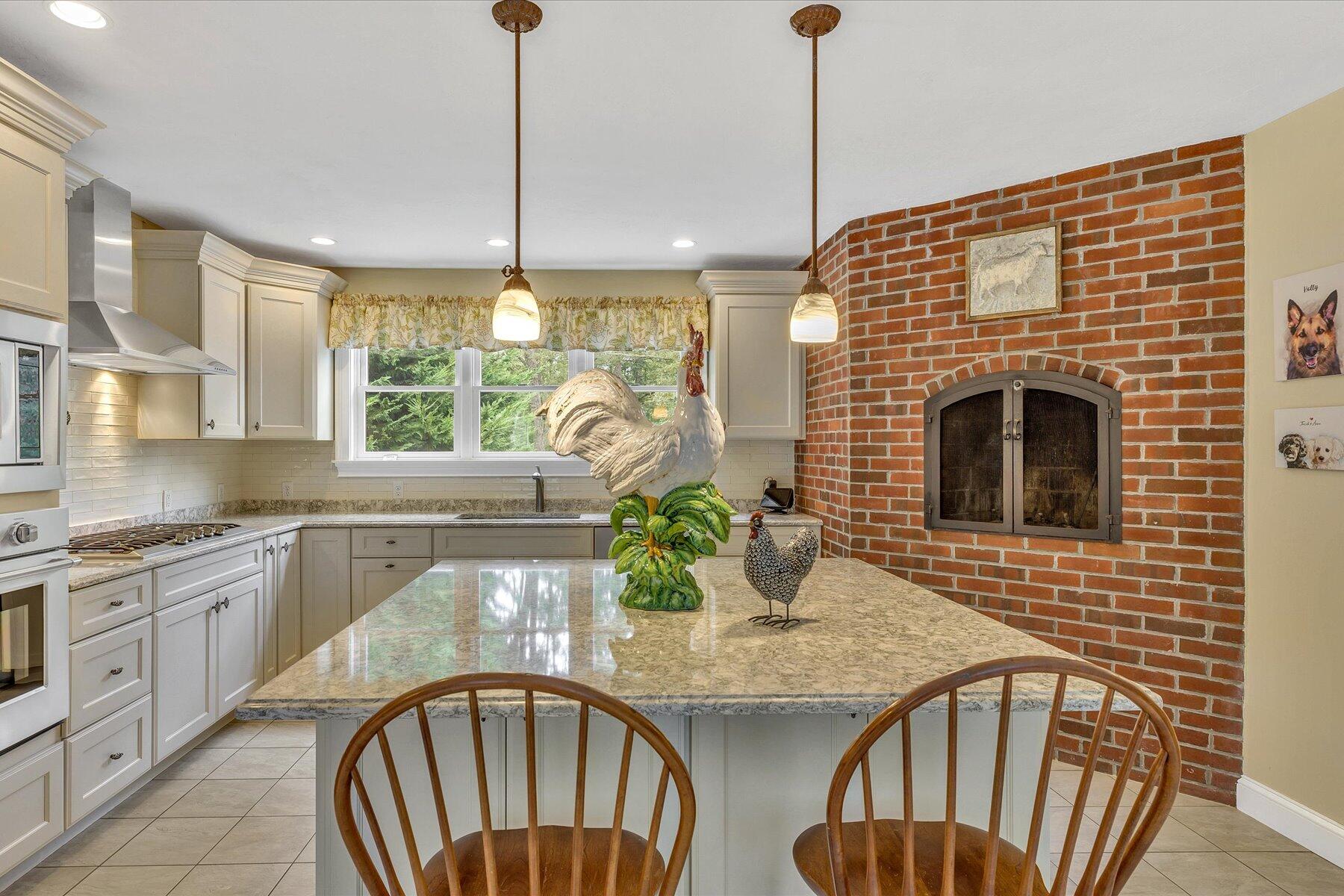 663 Crowells Bog Road Brewster, MA 02631 - Photo 11 of 46 a kitchen with stainless steel appliances granite countertop a stove top oven a dining table and chairs