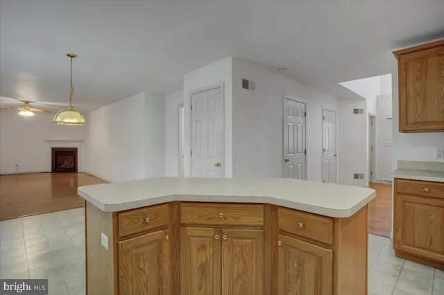 a view of an empty room with a chandelier fan