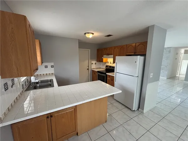 a kitchen with stainless steel appliances a refrigerator sink and cabinets