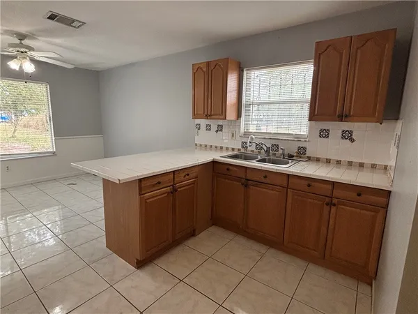 a kitchen with a sink window and cabinets