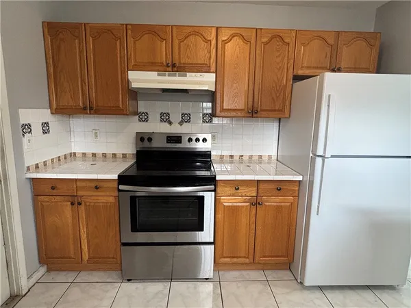 a kitchen with stainless steel appliances granite countertop a refrigerator stove and sink