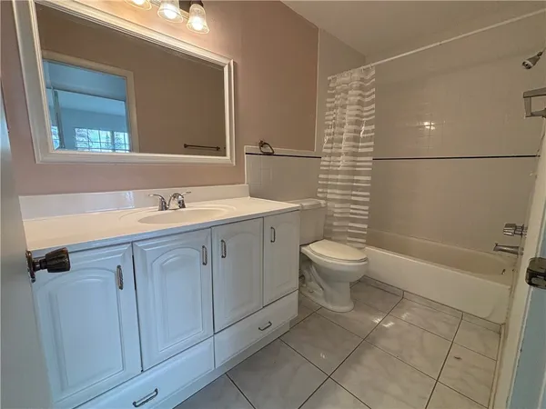 a bathroom with a double vanity sink toilet mirror and shower