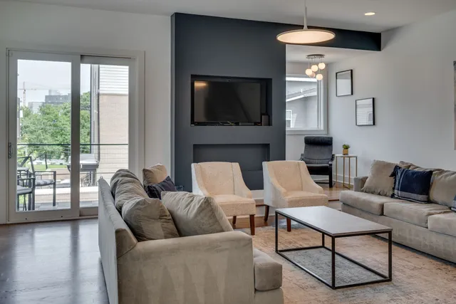 a living room with furniture a flat screen tv and a fireplace