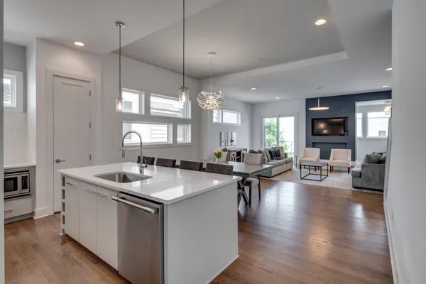 a kitchen with sink stove and living room