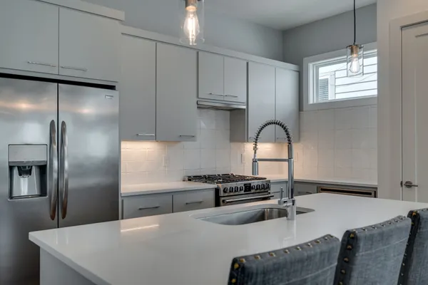 a kitchen with stainless steel appliances granite countertop a sink a stove and a refrigerator