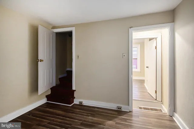 a view of a hallway with wooden floor and closet