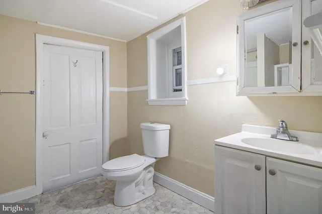 a bathroom with a toilet a sink and mirror