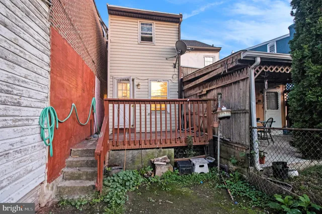 a view of a house with a small yard and wooden floor and fence