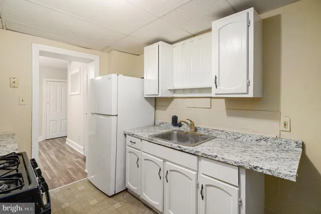 a kitchen with granite countertop a sink stove and refrigerator