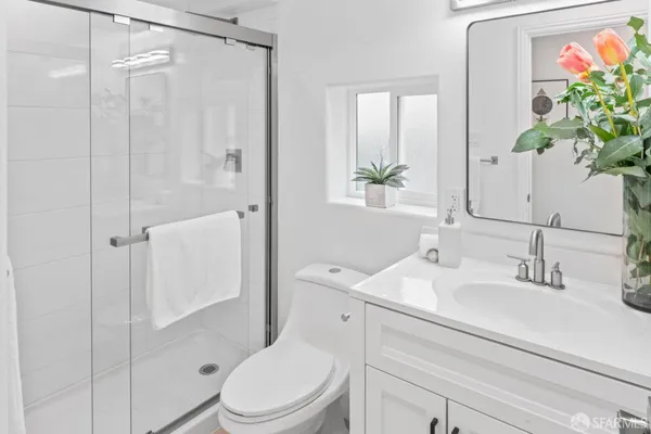 a bathroom with a sink a toilet and shower
