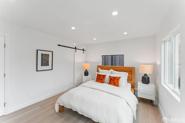 a bedroom with a bed and wooden floor