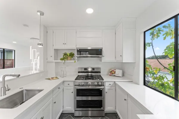 a kitchen with stainless steel appliances a stove sink and cabinets