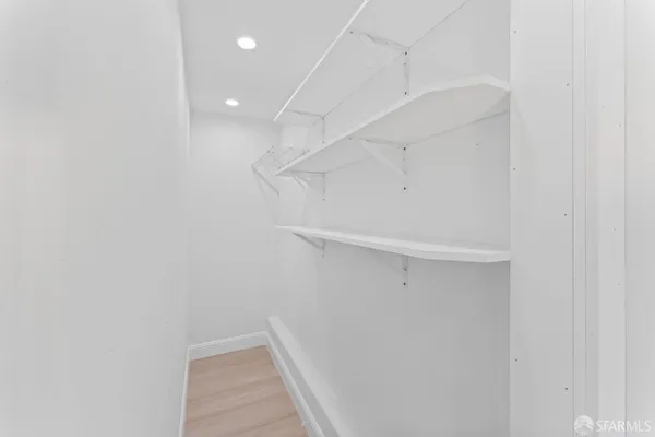a view of walk in closet with empty racks
