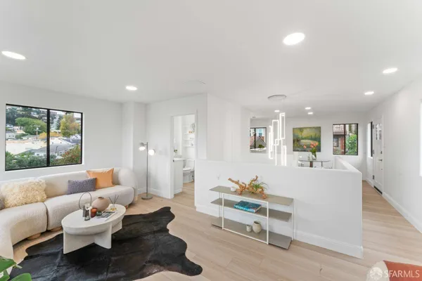a living room with furniture and wooden floor