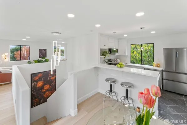 a kitchen with stainless steel appliances granite countertop a refrigerator a sink a stove and a refrigerator