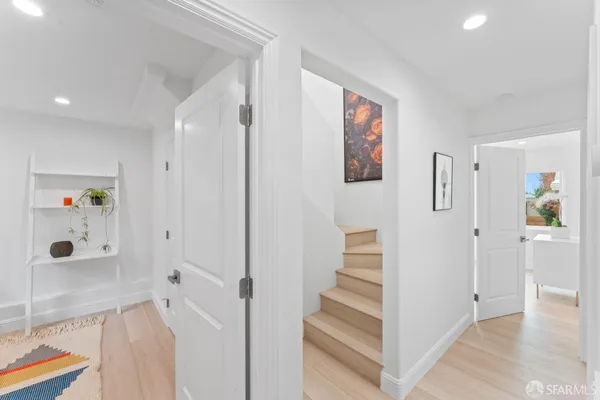 a view of a hallway with wooden floor and entryway