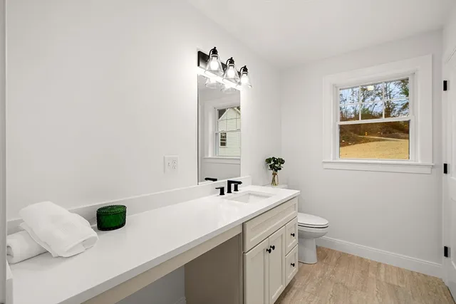 a bathroom with a sink a toilet and mirror