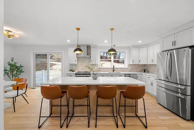 a kitchen with stainless steel appliances kitchen island a table and chairs in it