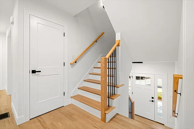 a view of a hallway with wooden floor and entryway