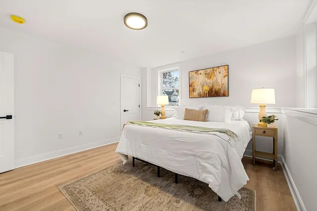 a bedroom with a bed and a painting on the wall